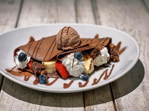 Une crêpe au froment nappée de caramel, avec une boule de glace